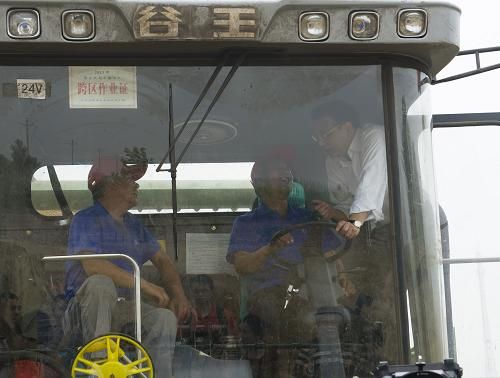  這是6月7日，李克強(qiáng)在邯鄲縣裴堡東村登上收割機(jī)駕駛室向農(nóng)機(jī)手了解小麥?zhǔn)粘汕闆r。新華社記者 黃敬文 攝