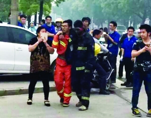 事故現(xiàn)場(chǎng)，受傷的消防隊(duì)員被隊(duì)友攙扶到一邊休息