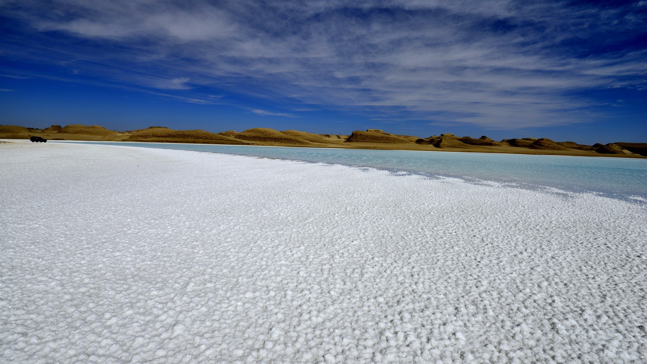巍巍遠山，青青鹽湖，白茫茫的鹽晶遍地，藍天下一望無際的鹽湖在風力的作用下蕩漾鹽花