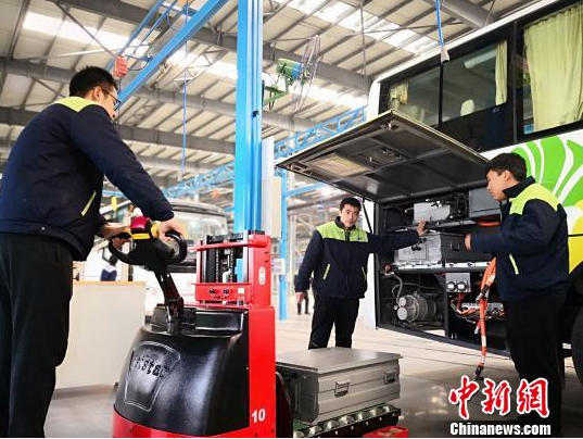 圖為工作人員在給新能源車輛安裝蓄電池。魏建軍 攝