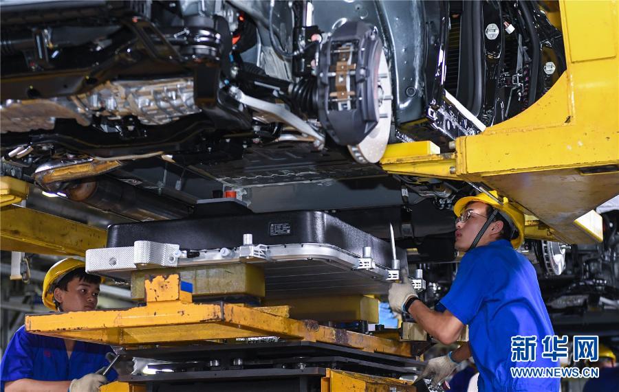 在深圳比亞迪總部，工人為新能源汽車安裝電池。新華社記者 毛思倩 攝