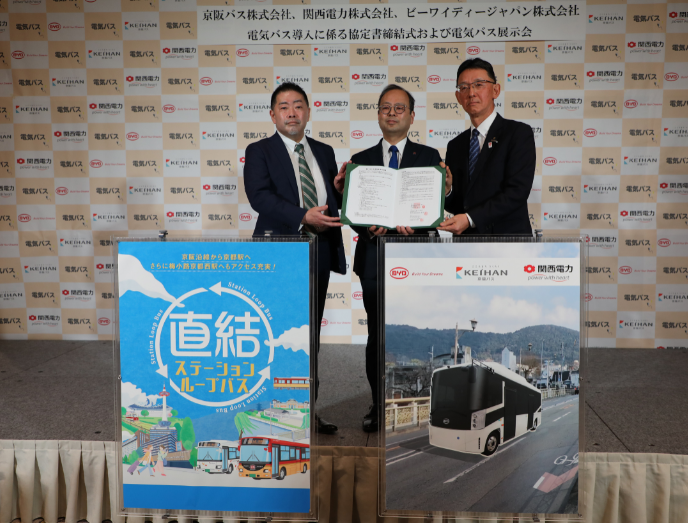 比亞迪日本有限公司執(zhí)行董事副社長花田晉作（左一）與京阪巴士總經(jīng)理鈴木一也（左二）及關(guān)西電力銷售及市場營銷部副總經(jīng)理藤野研一（右一）在活動現(xiàn)場合影留念